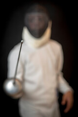 portrait of a young fencer athlete in ammunition