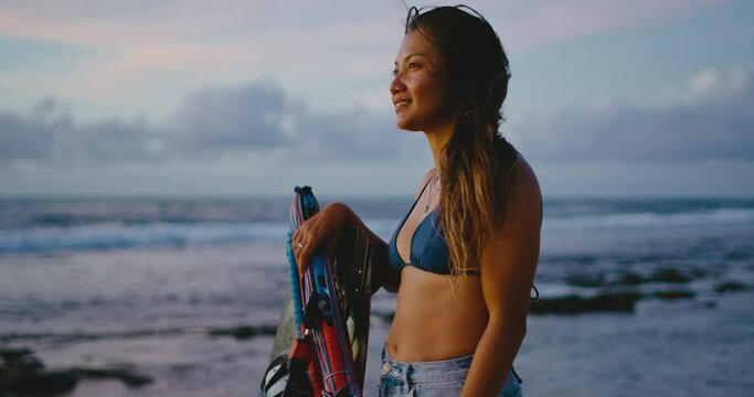 Portrait of beautiful woman kitesurfer on the beach at sunset, female extreme sports athlete, strong independent woman and diversity
