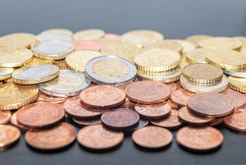 Coins and euro cents, on white surface. Wealth, savings, and rate hikes. 