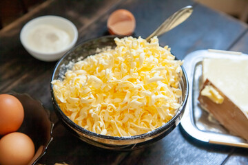 Grated butter for baking. Baking ingredients for shortbread pastry: butter, eggs, sour cream on wooden table
