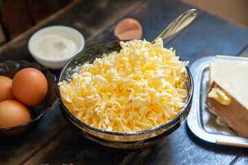 Grated butter for baking. Baking ingredients for shortbread pastry: butter, eggs, sour cream on a wooden table
