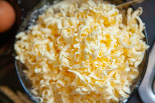 Grated butter for baking on table. Baking ingredients for shortbread pastry: grated butter, flour, eggs, sour cream on a wooden background