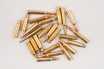 Pile of rifle bullets isolated on grey background. Top view.