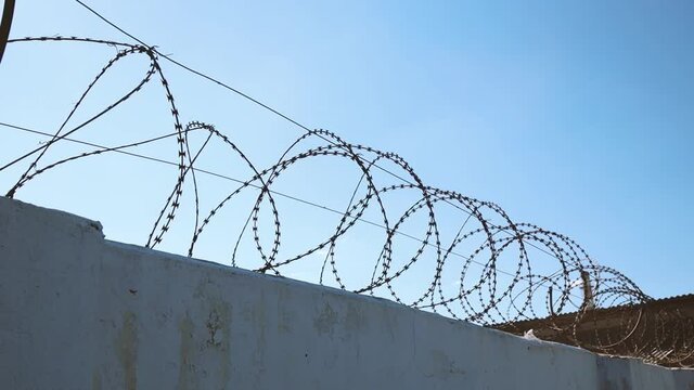 Concrete wall with barbed wire against migrants. Prison concept, rescue, refugee. Danger line