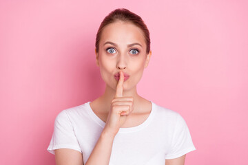 Fototapeta premium Photo of young woman cover lips finger shh keep secret confidential isolated over pink color background