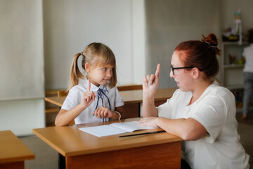 The teacher deals with the child with the girl, the teacher helps explain to the child in the...