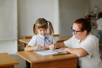 The teacher deals with the child with the girl, the teacher helps explain to the child in the...