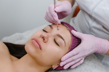 Obraz na płótnie Canvas hygienic facial procedure to female client in modern beauty salon