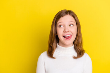 Photo of charming cheerful young small girl look empty space lick teeth tasty isolated on yellow color background - obrazy, fototapety, plakaty