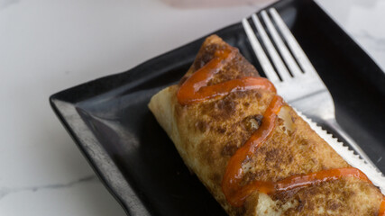 Burrito wraps with egg omelet and vegetables on plate. Turkish kebab with egg omelet and vegetables