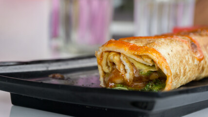 Burrito wraps with egg omelet and vegetables on plate. Turkish kebab with egg omelet and vegetables
