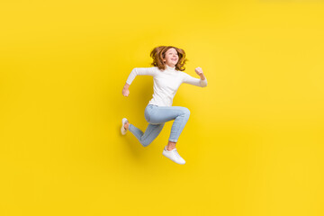 Fototapeta na wymiar Full body photo of cheerful dreamy happy small girl jump up runner empty space isolated on yellow color background