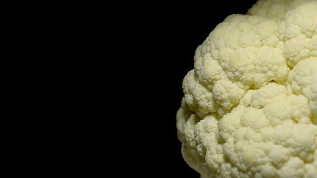 3.	Cauliflower on black background. Close-up. Large copyspace. Vegetarian food concept. Rotation