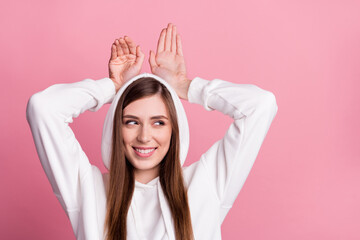 Naklejka premium Photo of young girl happy positive smile curious look empty space rabbit ears isolated over pink color background