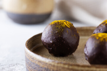 Chocolates with orange and turmeric in a bowl. Sugar, gluten and lactose free, vegan.