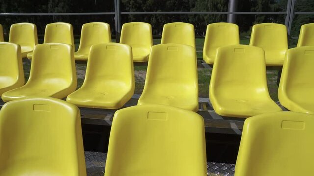 Empty stadium seats, empty bleachers. Rows of yellow seats without spectators in the sports arena