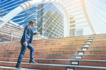 Young businessman walking in city for going to work with cityscape background.