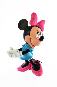 Studio image of a Minnie Mouse resin figure with a white isolated background. Minnie Mouse is standing holding her hands together striking one of her poses.
