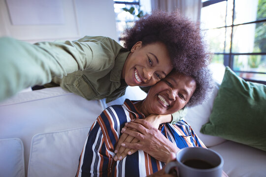 Portrait of smiling african american senior woman with adult daughter taking selfie