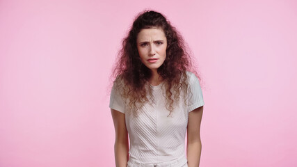 frustrated young woman looking at camera isolated on pink