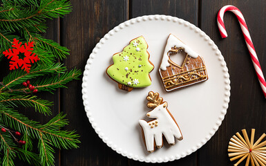 Christmas cookies on a plate on dark wooden background