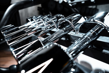 Fototapeta premium Rows of metal dumbbells on rack for bodybuilding in gym