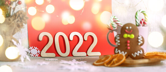 Fototapeta na wymiar Blurred Christmas celebration. Number 2022 with lights. Xmas holiday composition.