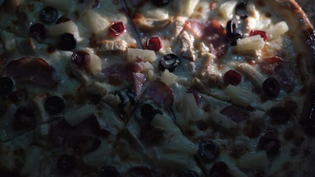 Pizza background with bacon and olives. Close-up of hot meat pizza in slices. Fast food background concept.