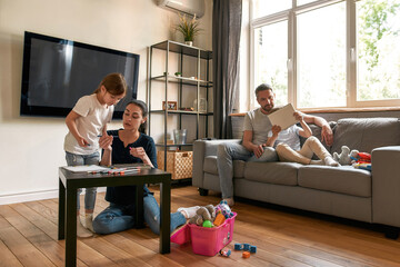 Young family with small kids relax at home on weekend