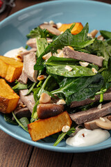 Closeup on bowl of healthy beef salad with potato and spinach