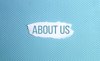 About us word written under ripped and torn paper.
