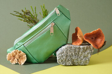 green belt bag made of eco leather on a stone, vegan leather from mushroom mycelium concept