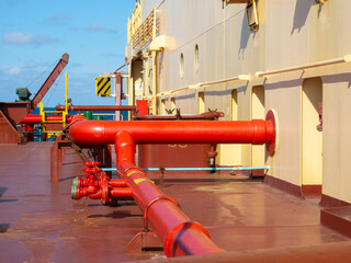 Marine fire extinguishing system with red pipes on a dry cargo ship. Fire safety concept