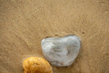 Pale blue pebble with a wet sand background