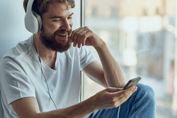 bearded man sitting in the room with headphones rest