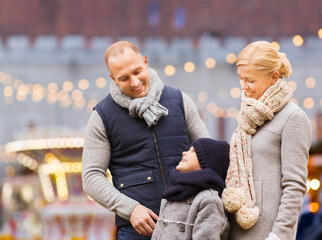 winter holidays, leisure and people concept - happy family talking over christmas market or...