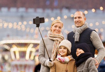 winter holidays, technology and people concept - happy family taking picture with smartphone and...