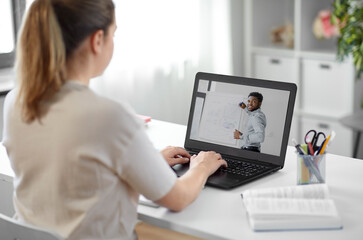 education, school and distant learning concept - student woman with teacher on laptop computer...