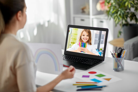 education, school and distant learning concept - female art teacher with laptop computer and picture of rainbow having online class with student girl at home