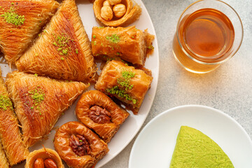Various Turkish sweets and cup of tea on white textured background