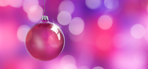 Glänzende Weihanchtskugel aus Glas vor unscharfem Hintergrund mit Lichtreflexen