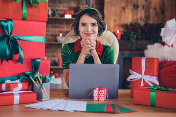 Photo of young woman elf santa helper christmas sit desk laptop workplace good mood indoors inside house home - obrazy, fototapety, plakaty