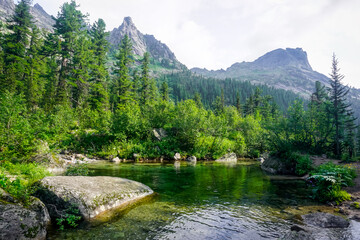 Fototapeta na wymiar A beautiful mountain lake of malachite color in the Ergaki Natural Park