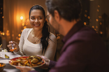 holidays, party and celebration concept - happy friends having christmas dinner at home