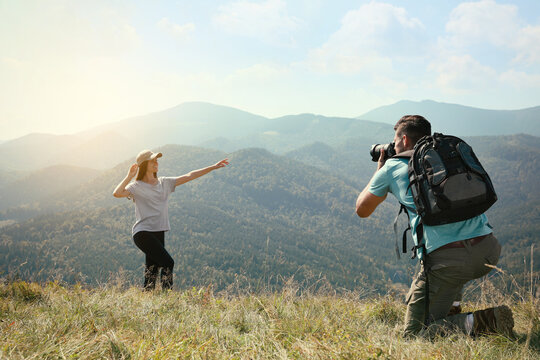 Professional photographer taking picture of woman in mountains