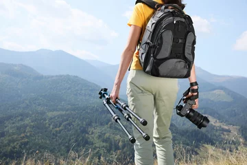 Tuinposter Professional photographer with modern camera and tripod in mountains, closeup © New Africa