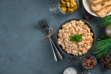 Olivier salad on a dark background with space to copy. Traditional Russian salad. Top view.