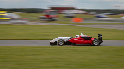 A panning shot of a racing car as it circuits a track.