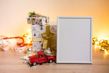 Portrait white picture frame mockup with christmas gifts, boken lights