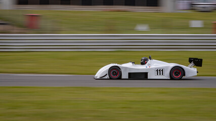 A panning shot of a racing car as it circuits a track.